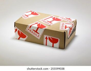 Ein brauner Karton mit roten Fragile-Aufklebern für den sicheren Transport.