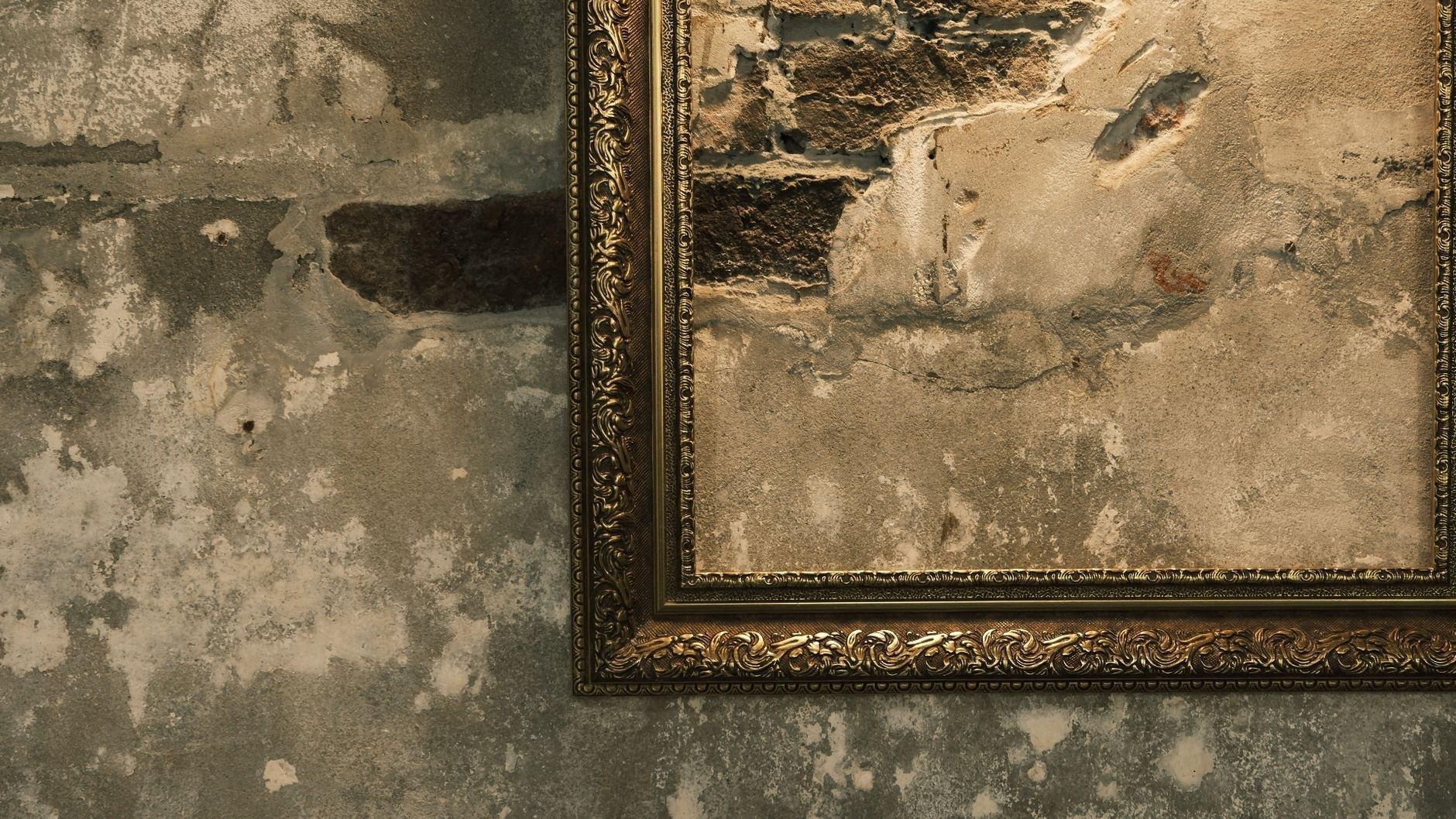 Ornamentaler Bilderrahmen vor einer verwitterten Steinwand
