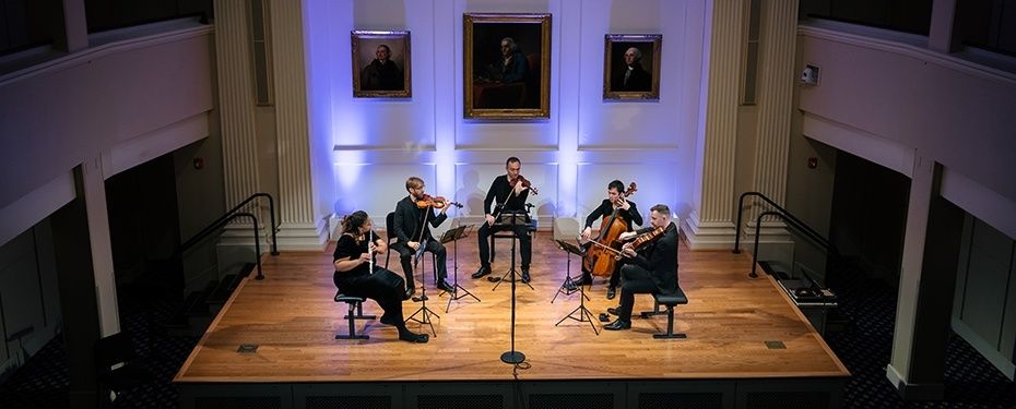 Fünf Musiker spielen Kammermusik auf einer beleuchteten Bühne